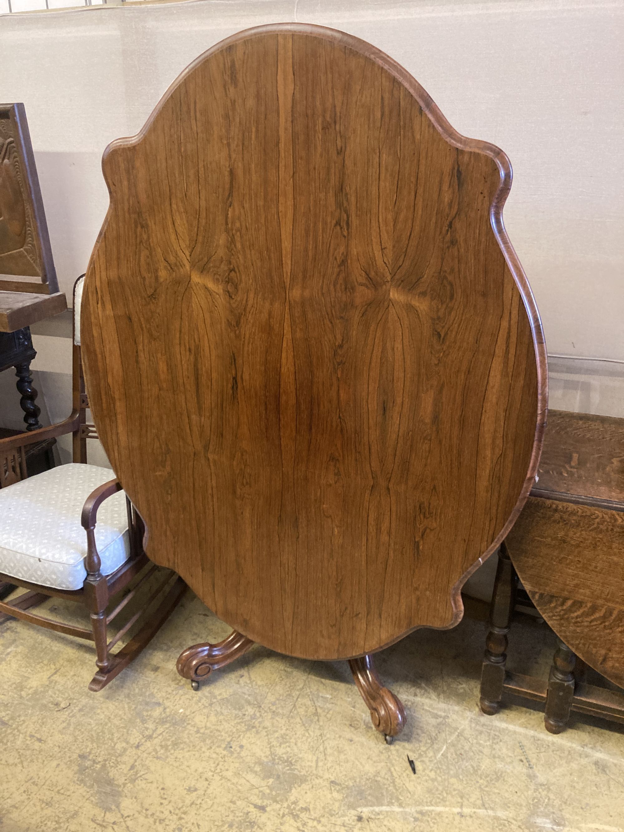 A Victorian rosewood oval tilt top loo table, length 150cm, depth 110cm, height 74cm and a matched set of six Victorian mahogany balloo